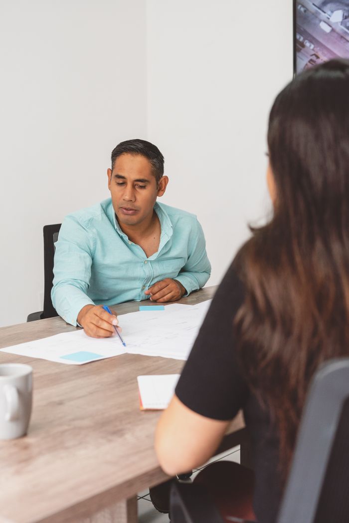 Mastering the First Impression: Your intriguing post title goes here Man and woman discussing project plans together in a modern office.